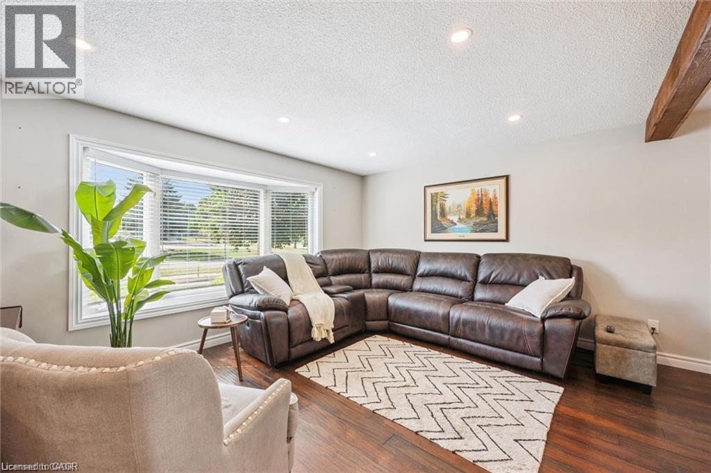 Spacious living area featuring a bay window with blinds, wood-finish flooring, and recessed ceiling lighting - 659 Glen Forrest Boulevard, Waterloo, ON - Indoor Photo Showing Living Room