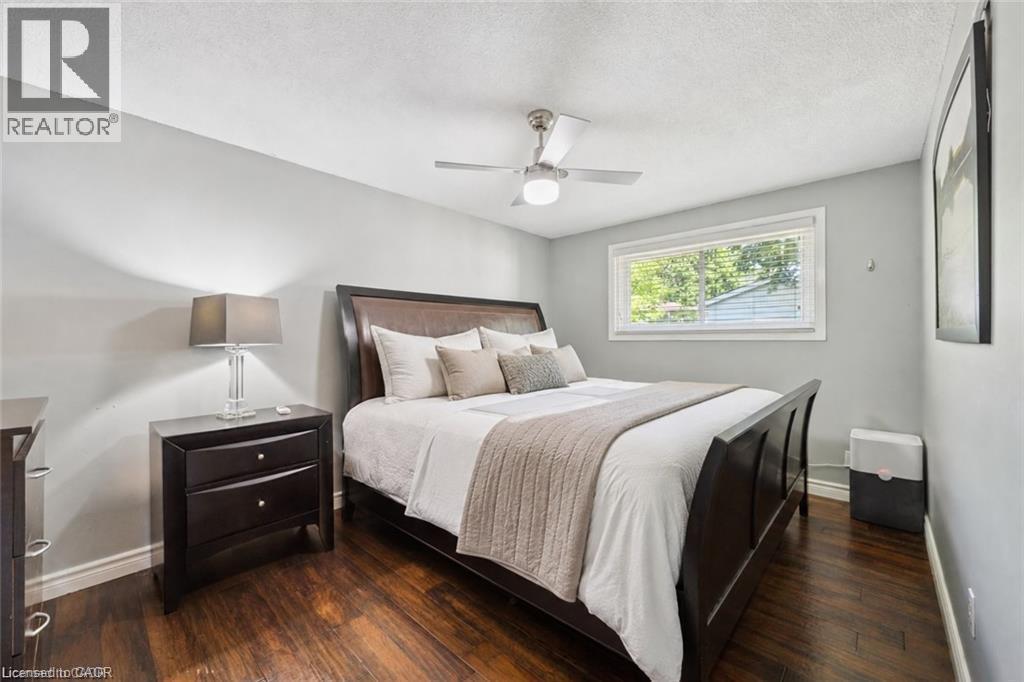 Hardwood-finish flooring, a ceiling fan with integrated lighting, and a single window with white trim - 659 Glen Forrest Boulevard, Waterloo, ON - Indoor Photo Showing Bedroom