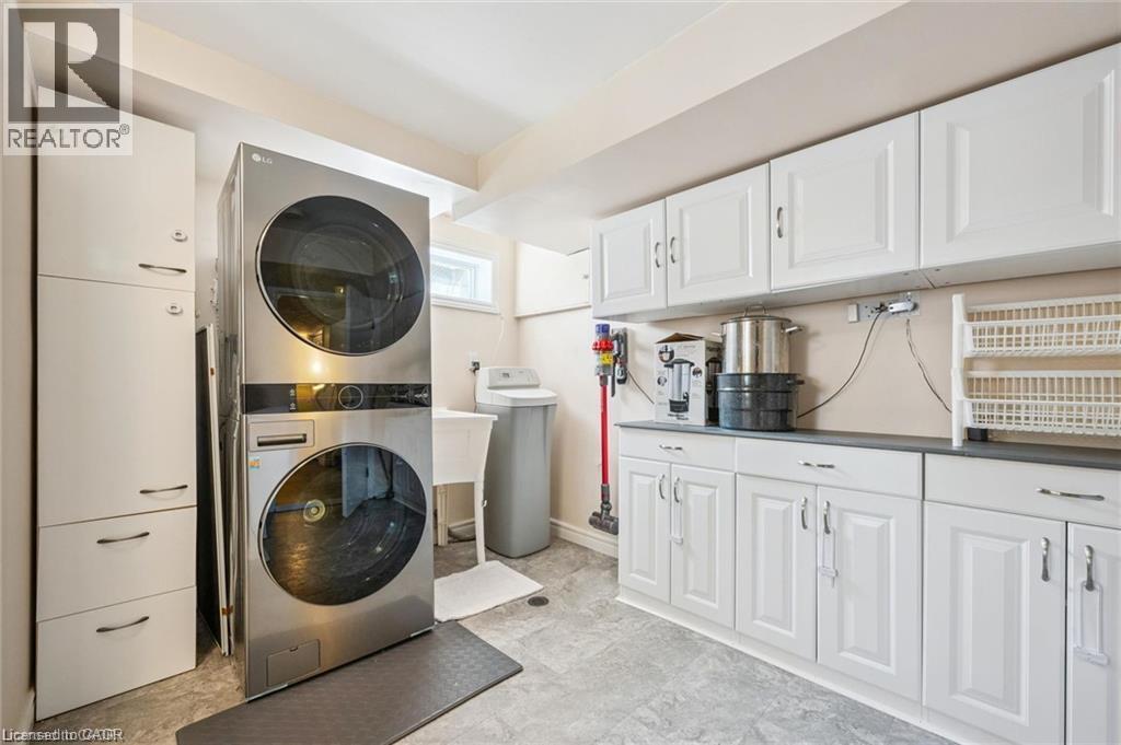 Integrated laundry appliances with white cabinetry, a utility sink, and ample counter space - 659 Glen Forrest Boulevard, Waterloo, ON - Indoor Photo Showing Laundry Room