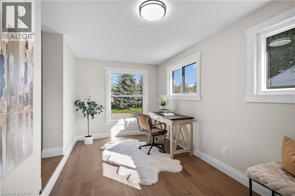 Wood-finish flooring with white trim and multiple windows - 1041 Shepherd'S Drive, Burlington, ON - Indoor Photo Showing Office