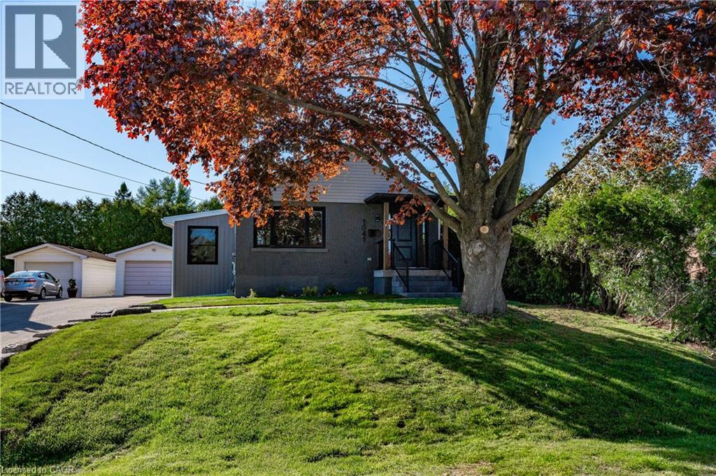 Property features a gray exterior with contrasting light gray siding, multiple windows, and a mature tree - 1041 Shepherd'S Drive, Burlington, ON - Outdoor