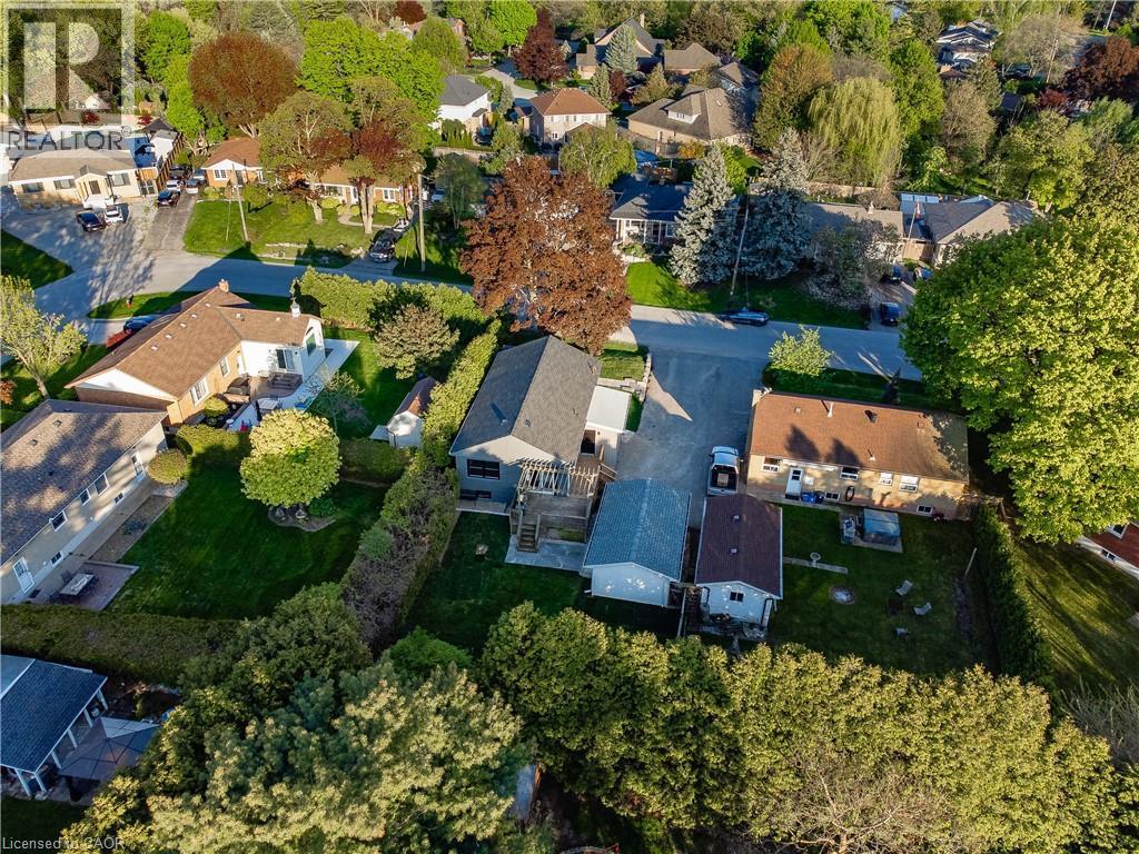 Aerial perspective showcasing a residence nestled on a mature, tree-lined lot with expansive grounds - 1041 Shepherd'S Drive, Burlington, ON - Outdoor With View