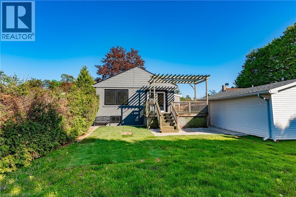Expansive lawn with a raised wood deck, pergola, and exterior siding - 1041 Shepherd'S Drive, Burlington, ON - Outdoor
