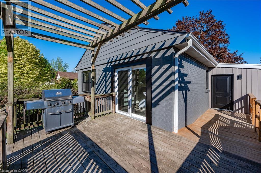 Expansive wood deck with a pergola, featuring a sliding glass door entry and a secondary access door - 1041 Shepherd'S Drive, Burlington, ON - Outdoor