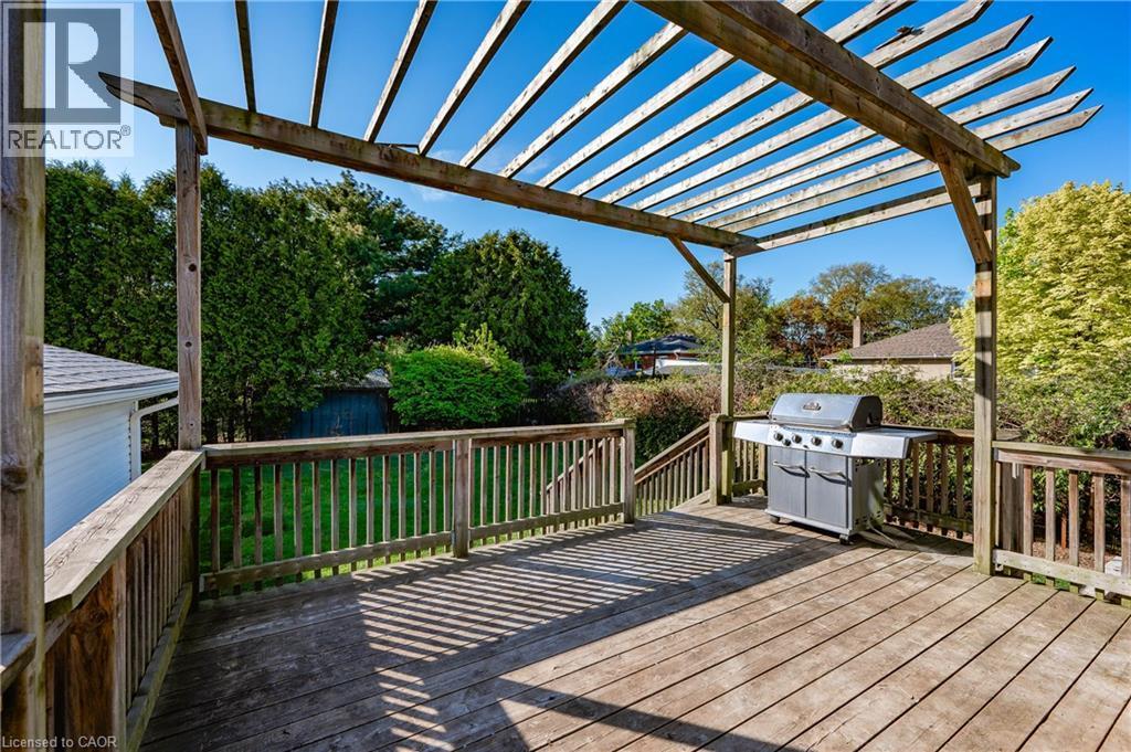 Expansive wood-finish deck with a built-in pergola, wood-slat railings, and stairs - 1041 Shepherd'S Drive, Burlington, ON - Outdoor With Deck Patio Veranda With Exterior