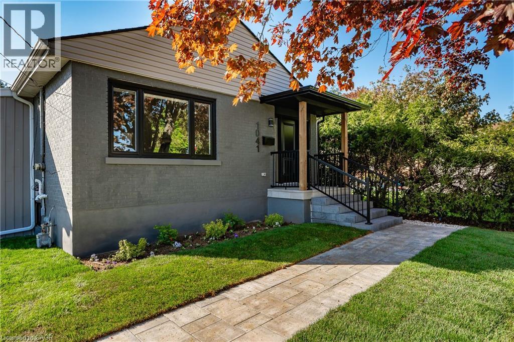 Exterior featuring a covered porch, wood posts, black railings, and a paver walkway - 1041 Shepherd'S Drive, Burlington, ON - Outdoor