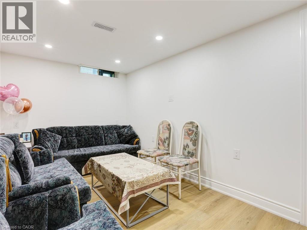 Finished basement recreation room featuring recessed ceiling lighting, wood-finish flooring, and neutral wall finishes - 128 Macatee Place, Cambridge, ON - Indoor Photo Showing Other Room