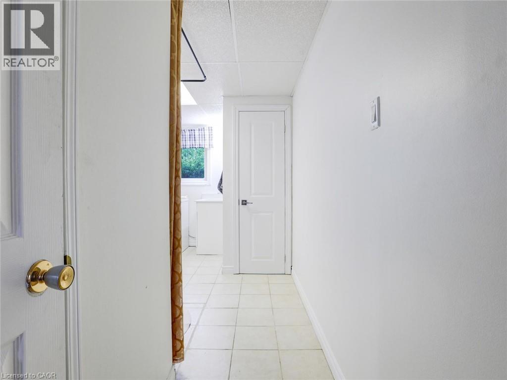 Hallway with white painted walls, square tile flooring, and white interior doors - 128 Macatee Place, Cambridge, ON - Indoor Photo Showing Other Room