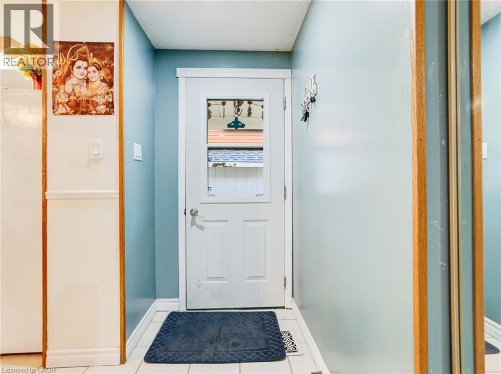 White door with clear glass panels, tile flooring, and light blue wall paint - 128 Macatee Place, Cambridge, ON - Indoor Photo Showing Other Room