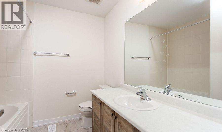 White tile flooring and bathtub surround - 16 Monteith Drive, Brantford, ON - Indoor Photo Showing Bathroom