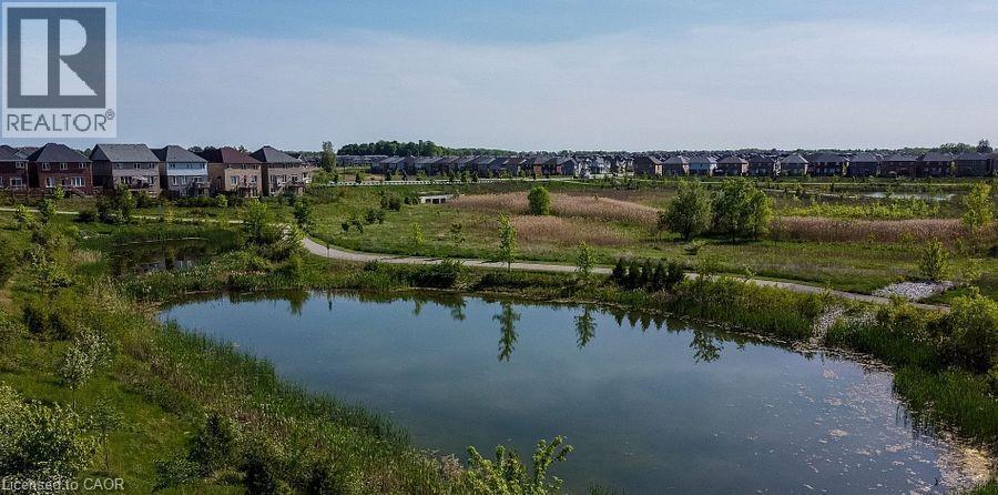 Expansive community featuring multiple residential properties, a large pond, and extensive green spaces with walking paths - 16 Monteith Drive, Brantford, ON - Outdoor With Body Of Water With View