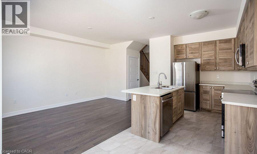 Spacious open-concept layout with wood-finish flooring - 16 Monteith Drive, Brantford, ON - Indoor Photo Showing Kitchen