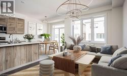 Open-concept living area with wood-finish cabinetry, stainless steel appliances, and a large window - 