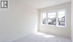 Neutral wall color, carpet flooring, and a large three-panel window - 
