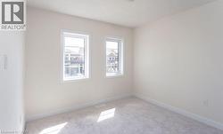 Neutral-toned wall paint, two bright windows, and light gray carpeting - 