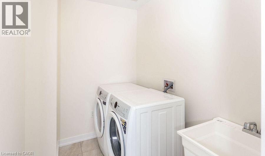 Utility room featuring a laundry basin with chrome faucet and tile flooring - 16 Monteith Drive, Brantford, ON - Indoor Photo Showing Laundry Room
