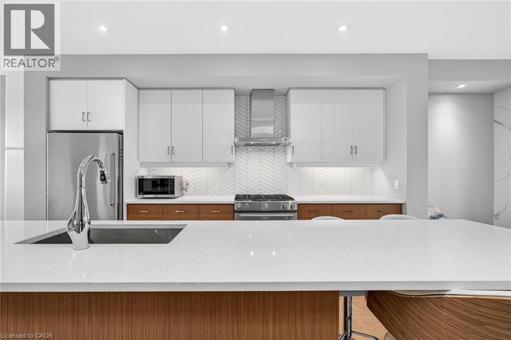Expansive quartz countertop with an undermount sink and chrome faucet - 60 Arkell Road Unit# 57, Guelph, ON - Indoor Photo Showing Kitchen With Upgraded Kitchen