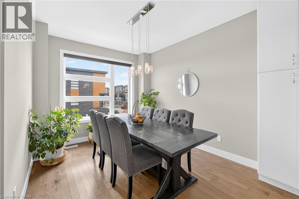 Large window with a roller shade, wood-finish flooring, and light gray walls - 60 Arkell Road Unit# 57, Guelph, ON - Indoor Photo Showing Dining Room