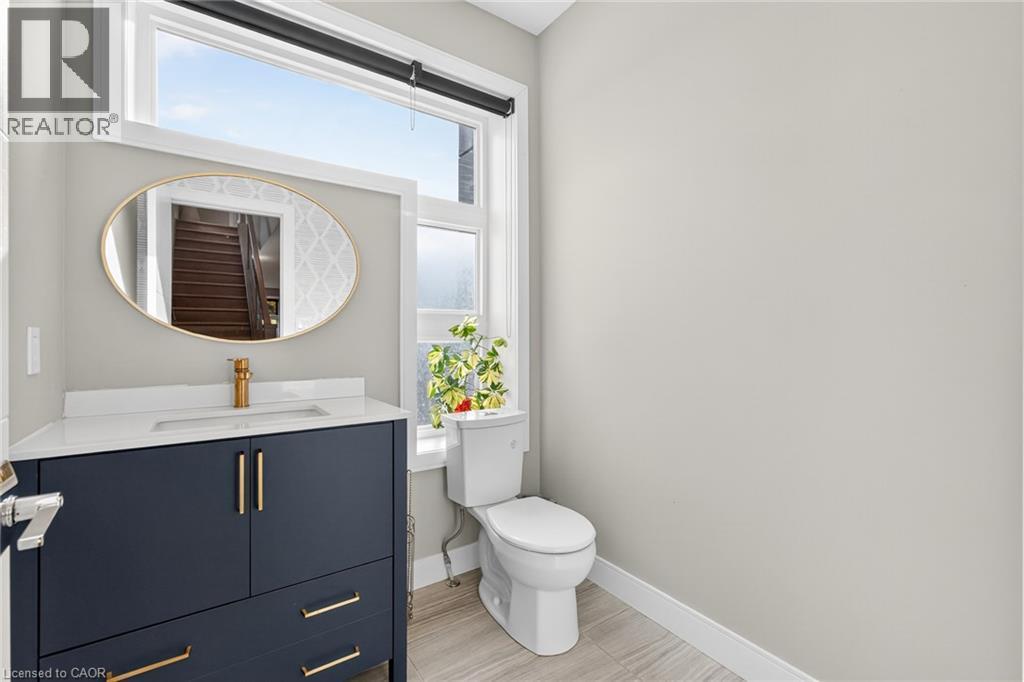 Modern vanity with a dark finish, white countertop, and gold-finish fixtures - 60 Arkell Road Unit# 57, Guelph, ON - Indoor Photo Showing Bathroom