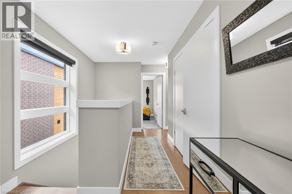 Hardwood-finish flooring, white paneled doors with chrome hardware, and a semi-flush mount ceiling light fixture - 60 Arkell Road Unit# 57, Guelph, ON - Indoor Photo Showing Other Room