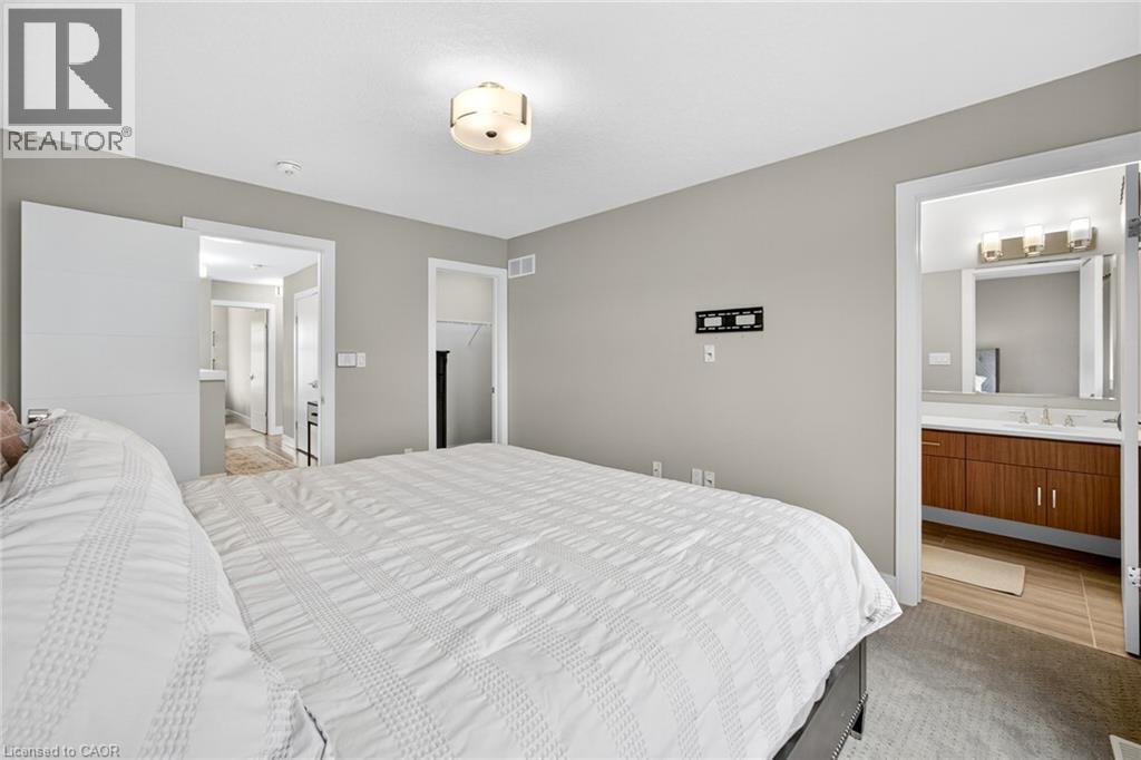 Recessed lighting, flush-mount ceiling light fixture, wall-mounted television bracket, neutral wall color, and carpeted flooring - 60 Arkell Road Unit# 57, Guelph, ON - Indoor Photo Showing Bedroom