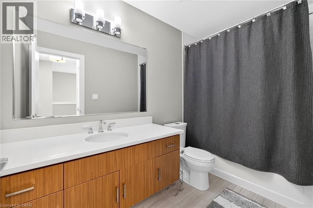 Wood-finish vanity with ample storage, a white countertop, and an undermount sink - 60 Arkell Road Unit# 57, Guelph, ON - Indoor Photo Showing Bathroom