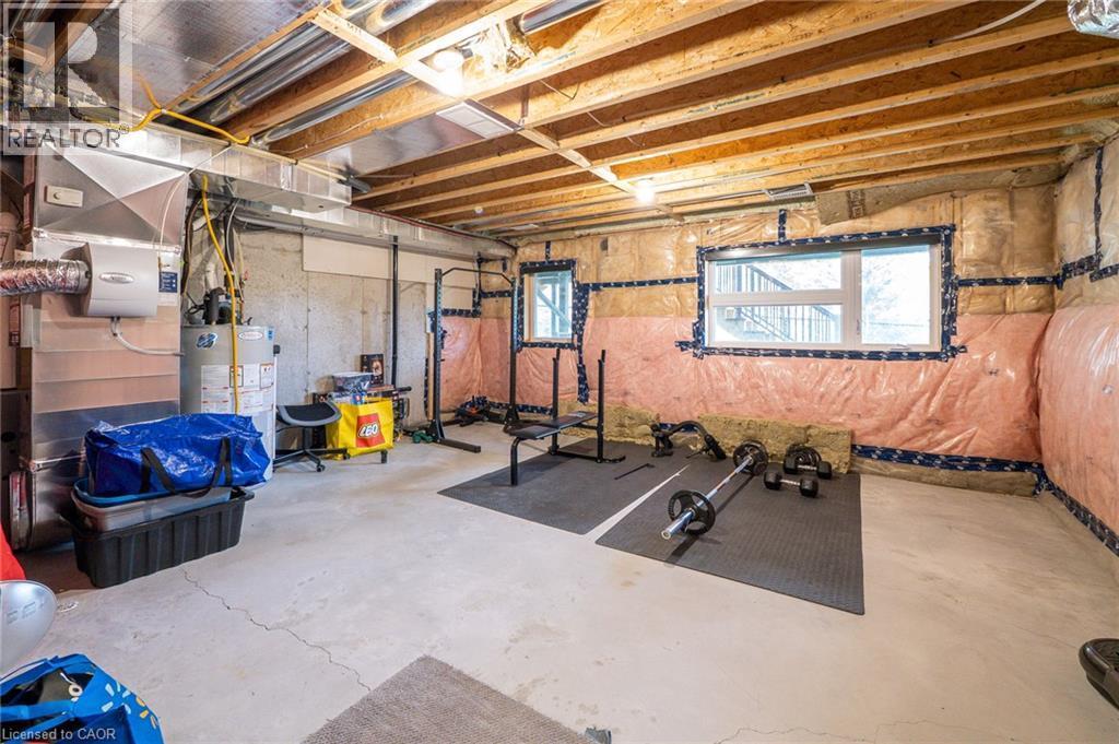 Unfinished lower level with exposed ceiling joists, concrete flooring, and multiple light fixtures - 60 Arkell Road Unit# 57, Guelph, ON - Indoor Photo Showing Basement