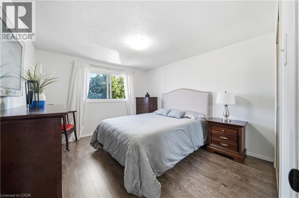 Wood-finish flooring, white walls, and a window with a white frame - 230 Sunset Boulevard, Cambridge, ON - Indoor Photo Showing Bedroom