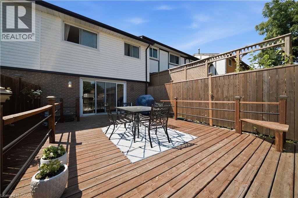 Expansive wood-finish deck with built-in railing, sliding glass door access, and a wood-slat fence - 230 Sunset Boulevard, Cambridge, ON - Outdoor With Deck Patio Veranda With Exterior