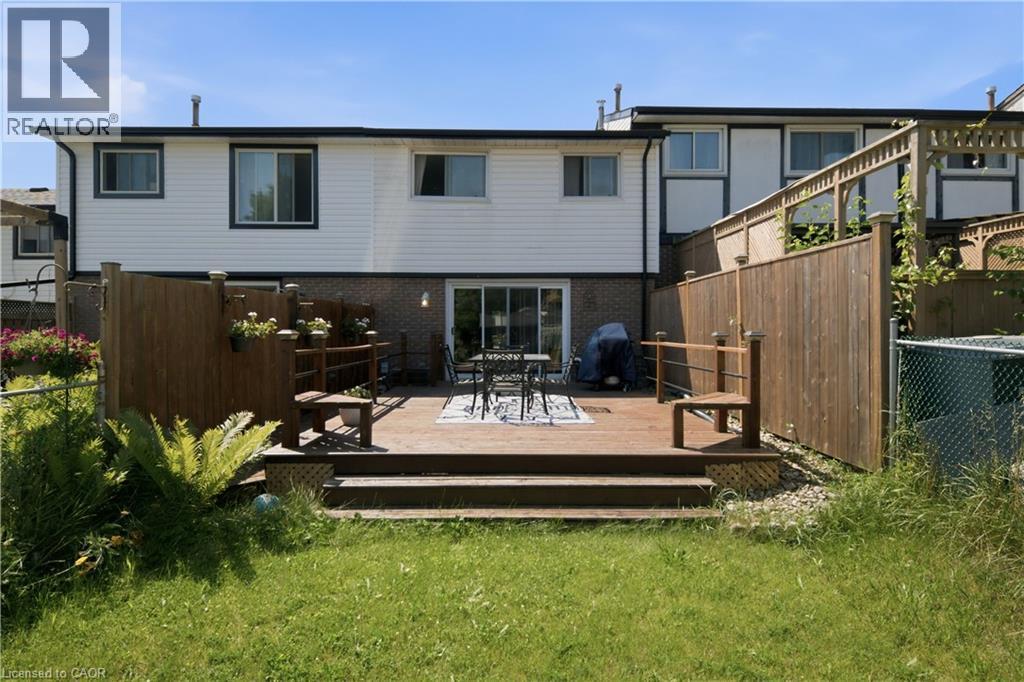 Expansive wood-finish deck with privacy fencing, offering direct access to the interior via a sliding glass door - 230 Sunset Boulevard, Cambridge, ON - Outdoor With Exterior
