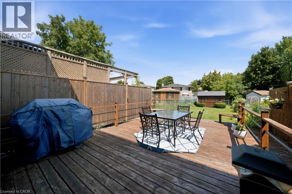 Expansive wood deck with a privacy fence, leading to a green lawn with mature trees and a storage shed - 230 Sunset Boulevard, Cambridge, ON - Outdoor With Deck Patio Veranda With Exterior