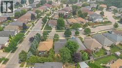 Residential neighborhood featuring a grid-pattern street layout, mature trees, sidewalks, and a variety of detached homes - 