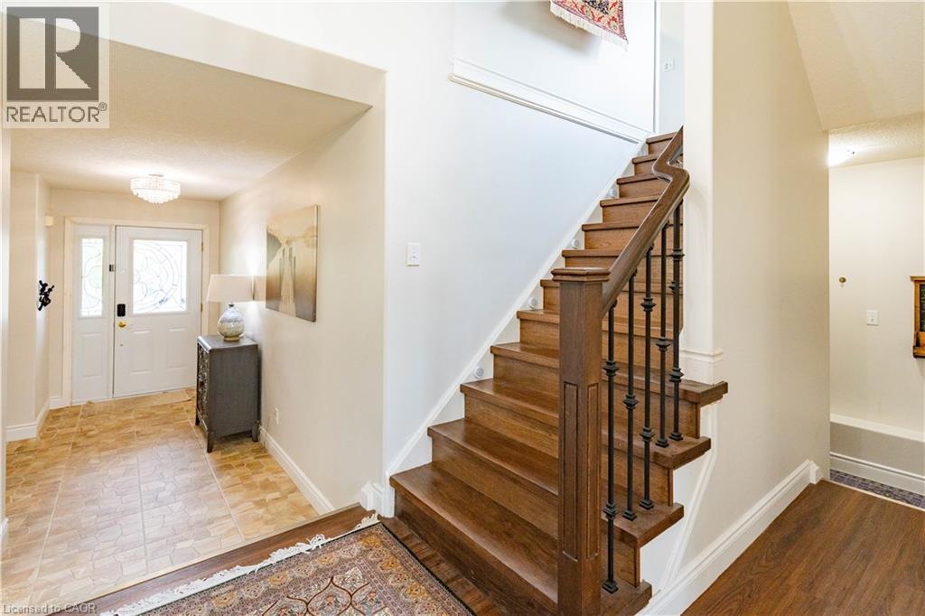 Wood staircase with wrought iron balusters - 122 Iron Gate Street, Kitchener, ON - Indoor Photo Showing Other Room