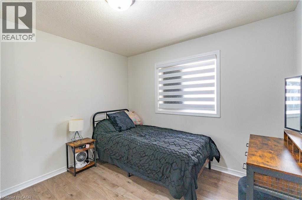 Wood-finish flooring with white walls - 122 Iron Gate Street, Kitchener, ON - Indoor Photo Showing Bedroom