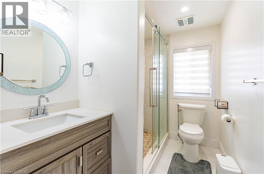 Vanity with wood-finish cabinetry and light-toned countertop - 122 Iron Gate Street, Kitchener, ON - Indoor Photo Showing Bathroom