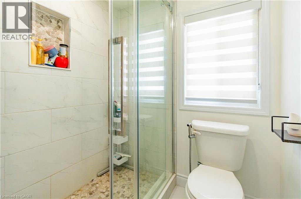 Glass-enclosed shower with subway tile surround and mosaic-tiled shower niche - 122 Iron Gate Street, Kitchener, ON - Indoor Photo Showing Bathroom