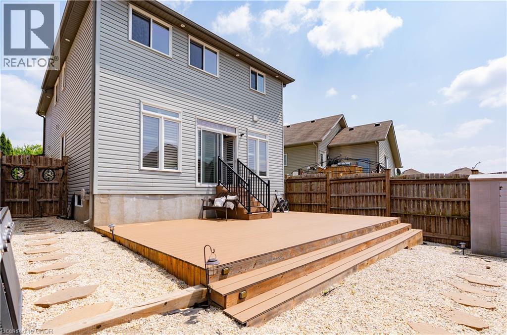 Expansive outdoor decking with multiple steps, sliding glass door access, white window frames, and light-colored siding - 122 Iron Gate Street, Kitchener, ON - Outdoor With Deck Patio Veranda With Exterior