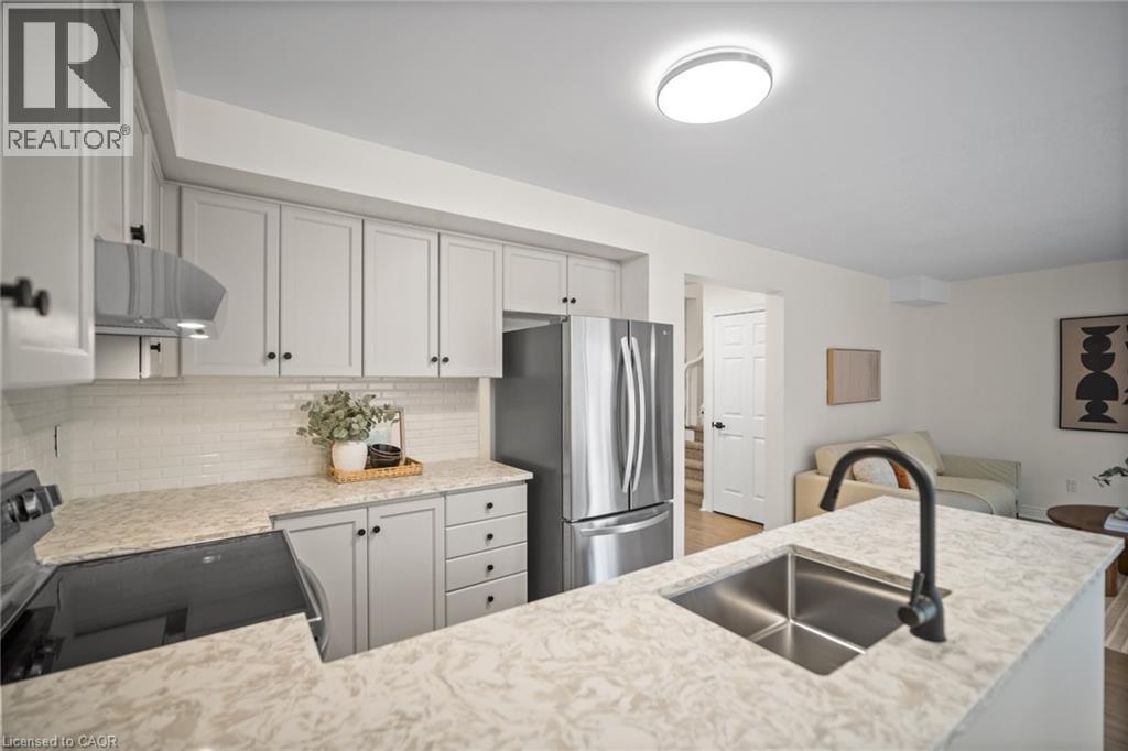 Kitchen featuring light-toned cabinetry, a subway tile backsplash, and light-toned countertops - 320 Hamilton Drive Unit# 10, Ancaster, ON - Indoor Photo Showing Kitchen With Double Sink With Upgraded Kitchen