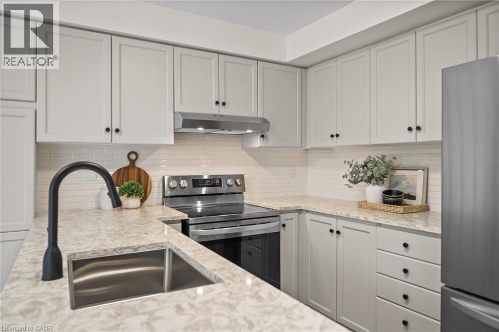 Light-toned cabinetry with black hardware, stainless steel appliances, speckled countertops, a matte black gooseneck faucet, and a white subway tile backsplash - 320 Hamilton Drive Unit# 10, Ancaster, ON - Indoor Photo Showing Kitchen With Double Sink With Upgraded Kitchen