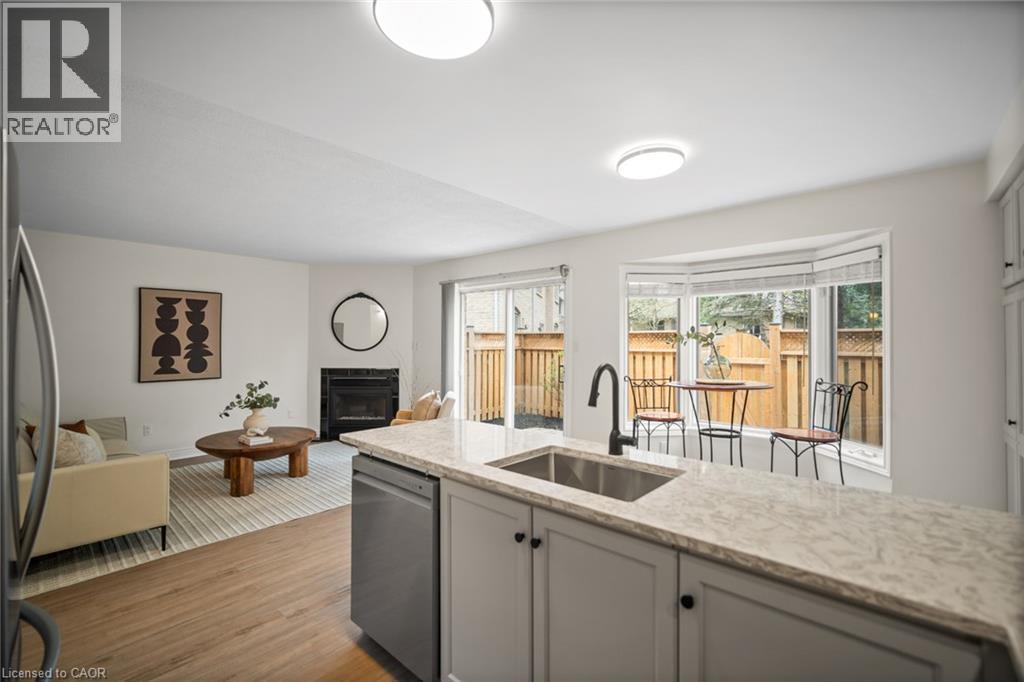 Kitchen island with stone-finish countertop, undermount sink, and matte black faucet - 320 Hamilton Drive Unit# 10, Ancaster, ON - Indoor Photo Showing Kitchen
