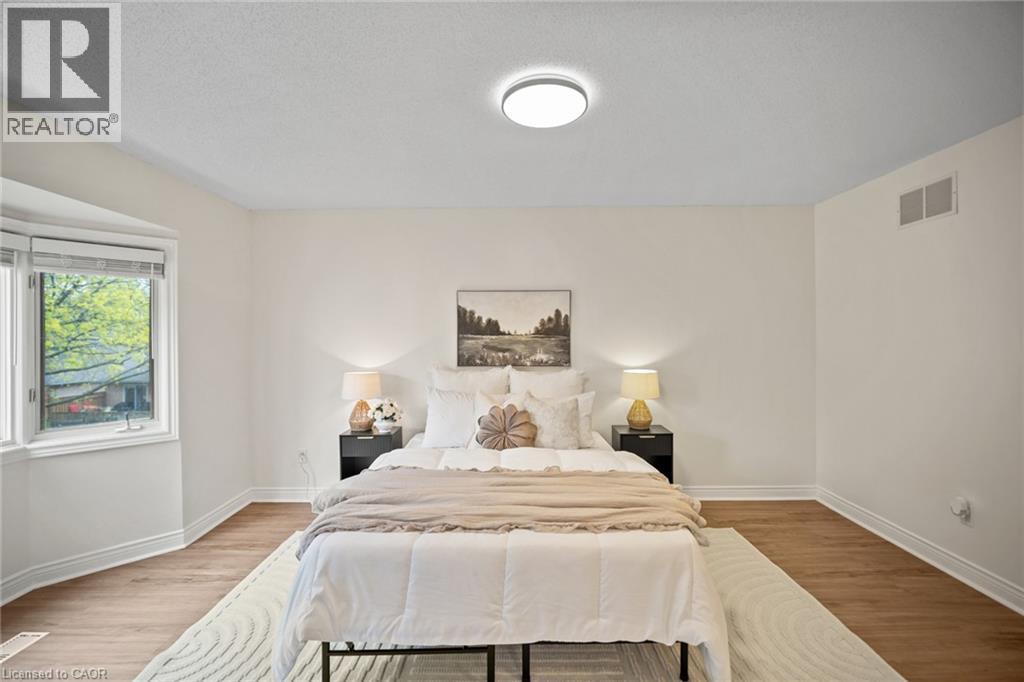 Wood-finish flooring, bay window, light fixture, crown molding, white painted walls - 320 Hamilton Drive Unit# 10, Ancaster, ON - Indoor Photo Showing Bedroom