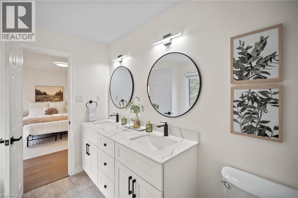 Double vanity with white cabinetry, black hardware, and integrated sinks - 320 Hamilton Drive Unit# 10, Ancaster, ON - Indoor Photo Showing Bathroom