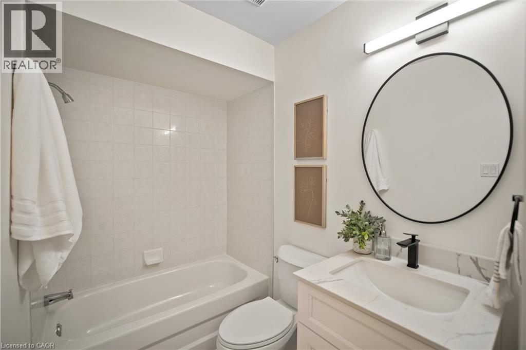 White tiled shower and tub combination - 320 Hamilton Drive Unit# 10, Ancaster, ON - Indoor Photo Showing Bathroom