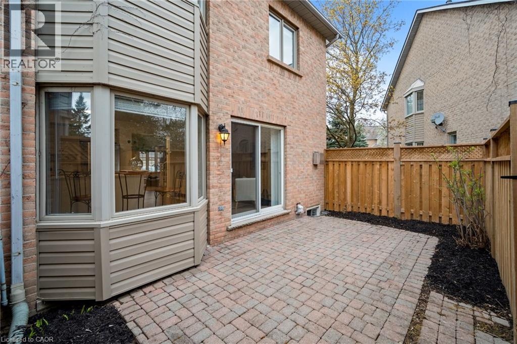 Brick exterior with a bay window, sliding glass door, and a paver patio - 320 Hamilton Drive Unit# 10, Ancaster, ON - Outdoor With Deck Patio Veranda With Exterior