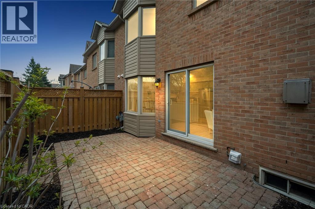 Brick exterior with a bay window and sliding glass door - 320 Hamilton Drive Unit# 10, Ancaster, ON - Outdoor With Exterior