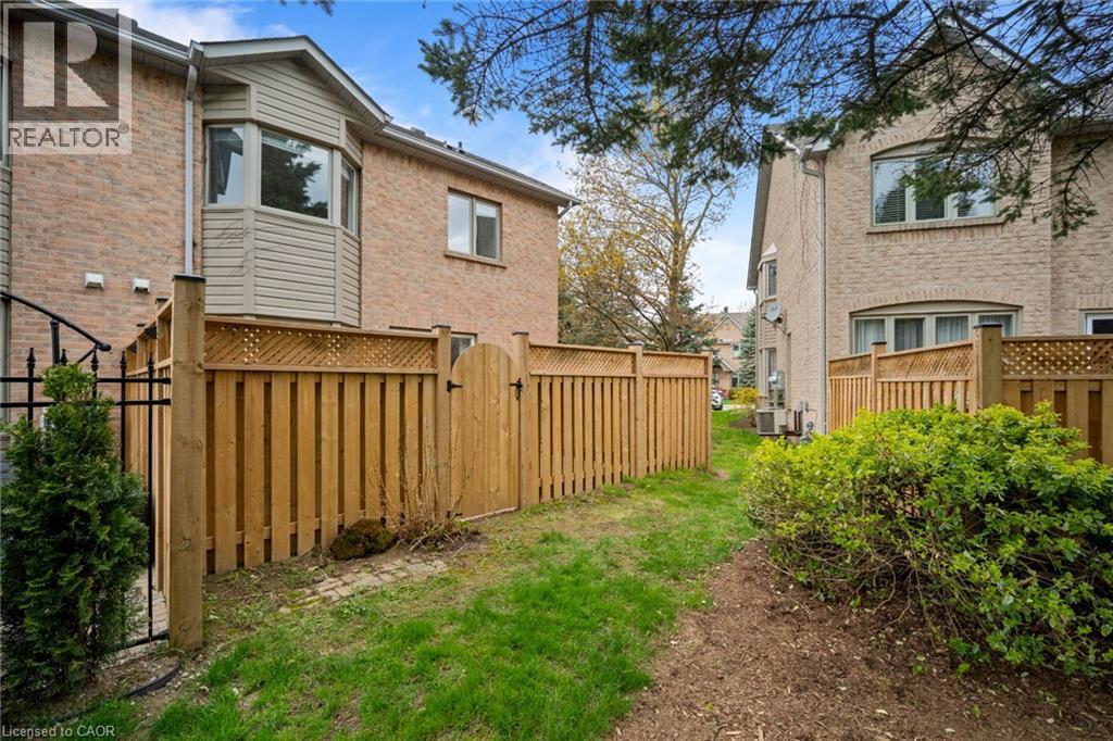 Private fenced backyard area with brick exterior and bay window feature - 320 Hamilton Drive Unit# 10, Ancaster, ON - Outdoor With Exterior