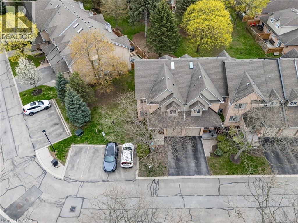 Townhome featuring a gabled roofline, front-facing garage, paved driveway, and landscaped front entry - 320 Hamilton Drive Unit# 10, Ancaster, ON - Outdoor