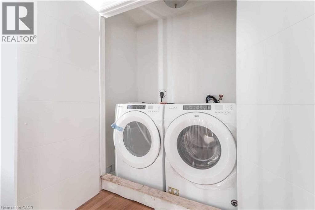 Laundry room with washer and clothes dryer and wood finished floors - 3 Coolwater Drive Unit# Upper, Brampton, ON - Indoor Photo Showing Laundry Room