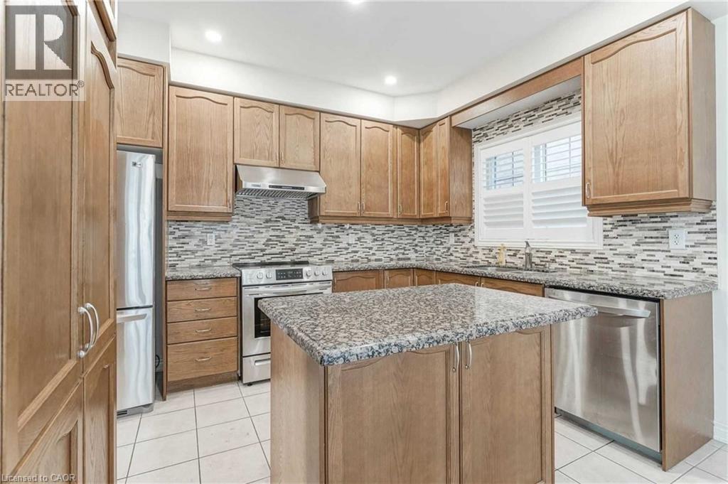 Kitchen featuring stainless steel appliances, under cabinet range hood, light tile patterned floors, stone counters, and recessed lighting - 3 Coolwater Drive Unit# Upper, Brampton, ON - Indoor Photo Showing Kitchen With Upgraded Kitchen