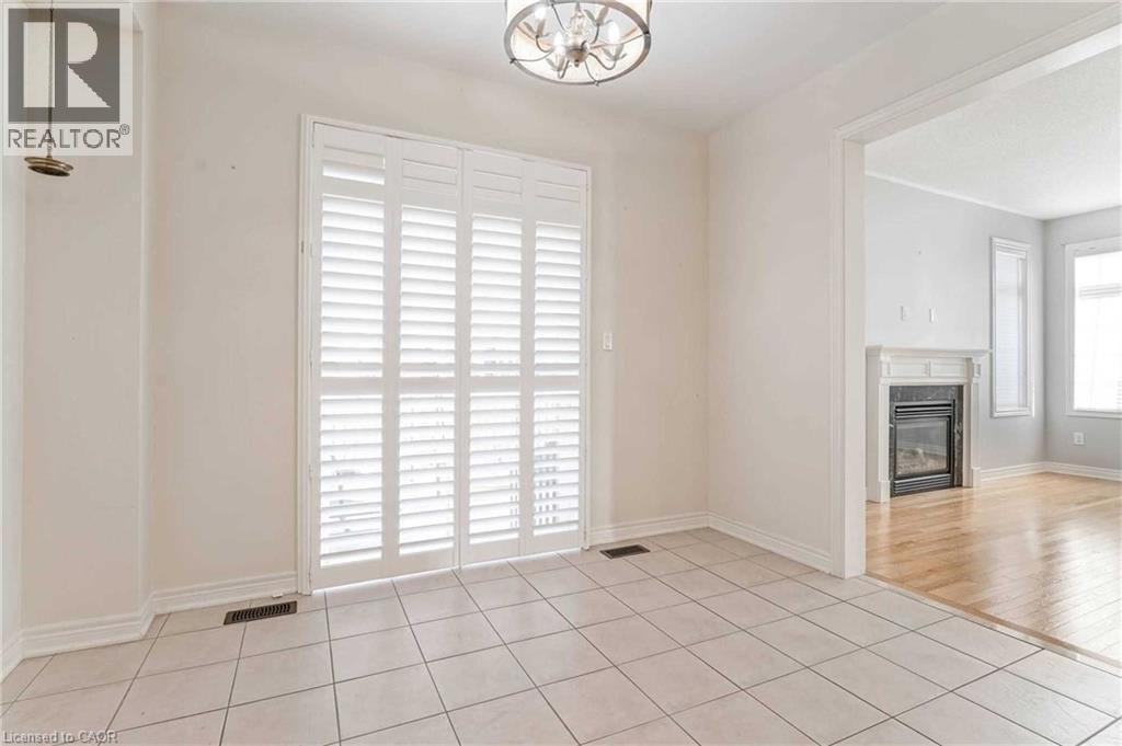 Unfurnished dining area with a chandelier, tile patterned flooring, and a fireplace - 3 Coolwater Drive Unit# Upper, Brampton, ON - Indoor With Fireplace